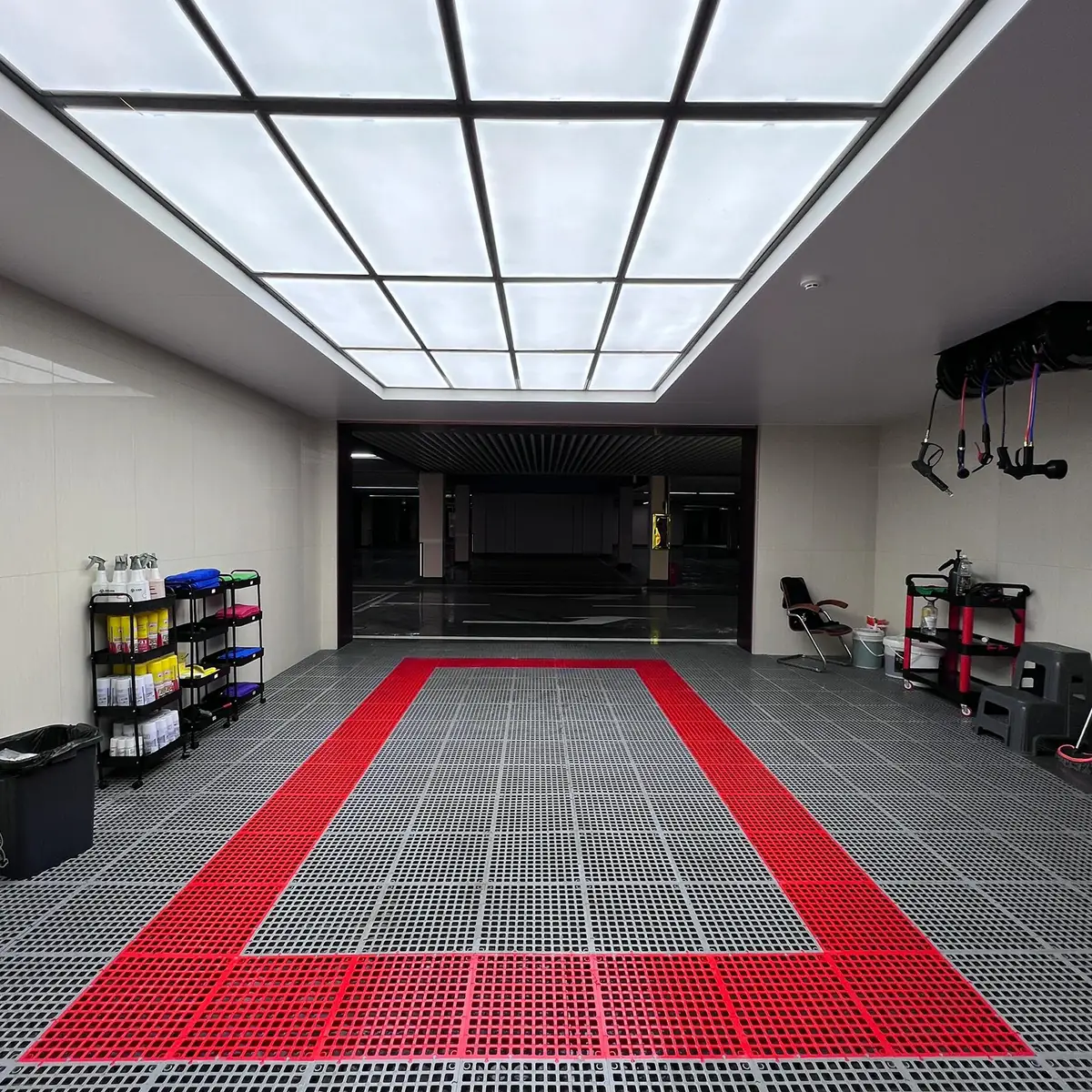 Gray modular garage floor with a red rectangular parking-zone border