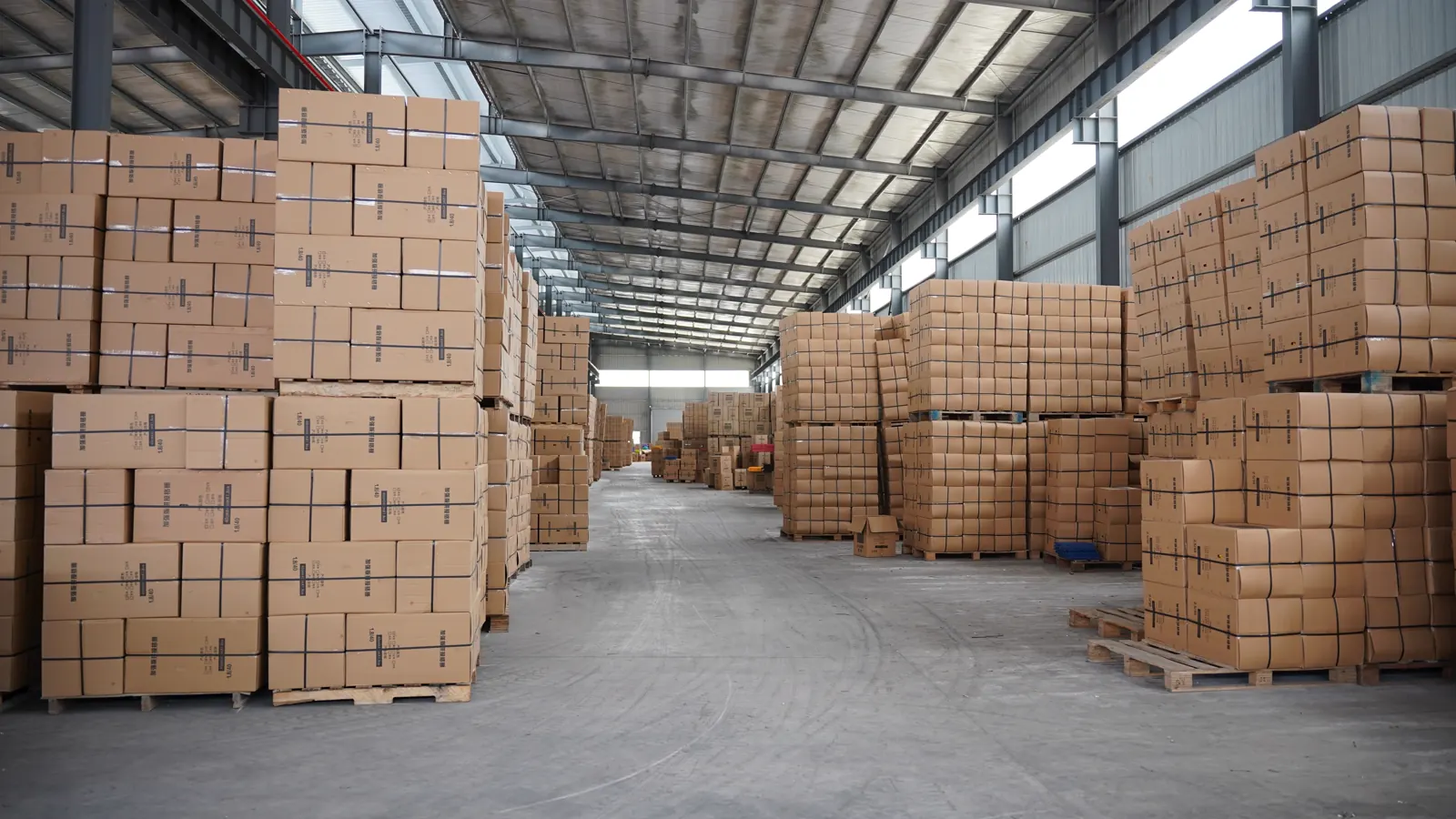 Palletized flooring cartons stored along a warehouse aisle